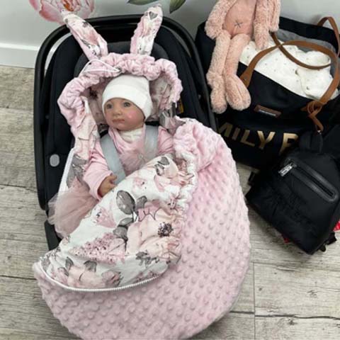 Bábätko v autosedačke zabalené v mäkkej deke do autosedačky BySues, praktická a teplá deka na bezpečné cestovanie.