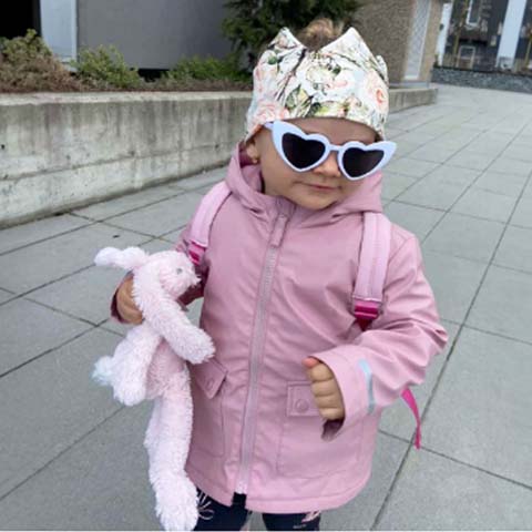 Dieťa v štýlovom detskom oblečení s korunkovou šatkou BySues a slnečnými okuliarmi, moderné oblečenie a doplnky pre deti na každý deň.