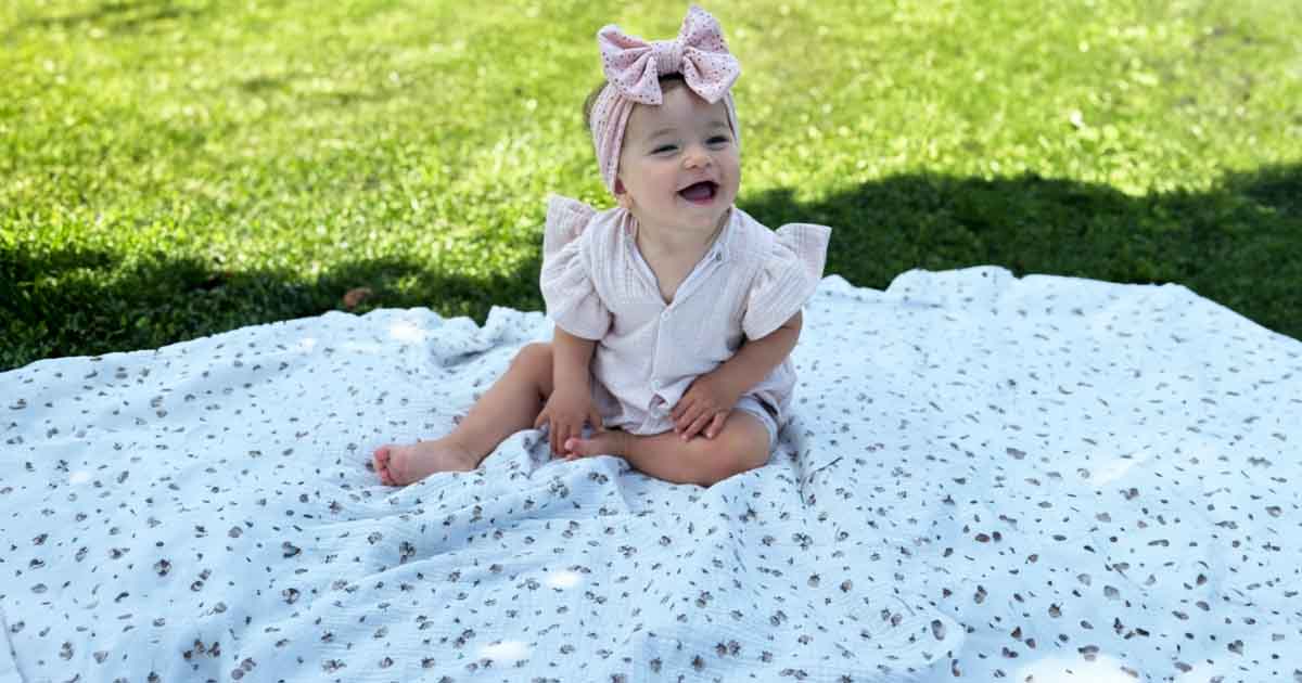 Bábätko sediace na mušelínovej detskej deke BySues, jemná a priedušná deka vhodná do postieľky, kočíka aj na hranie vonku.
