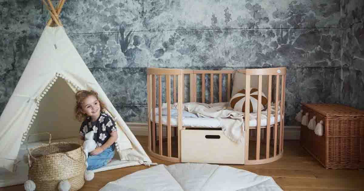 Rastúca detská postieľka s úložným boxom a doplnkami v detskej izbe, okrúhla drevená postieľka s textilnými dekoráciami